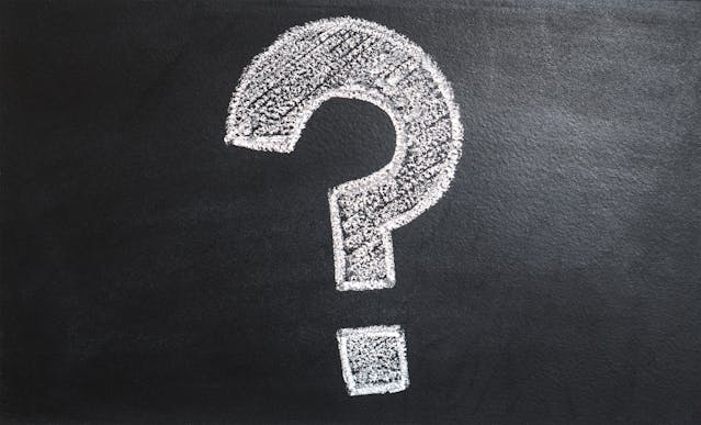 Chalk question mark on a blackboard – symbol of asking questions